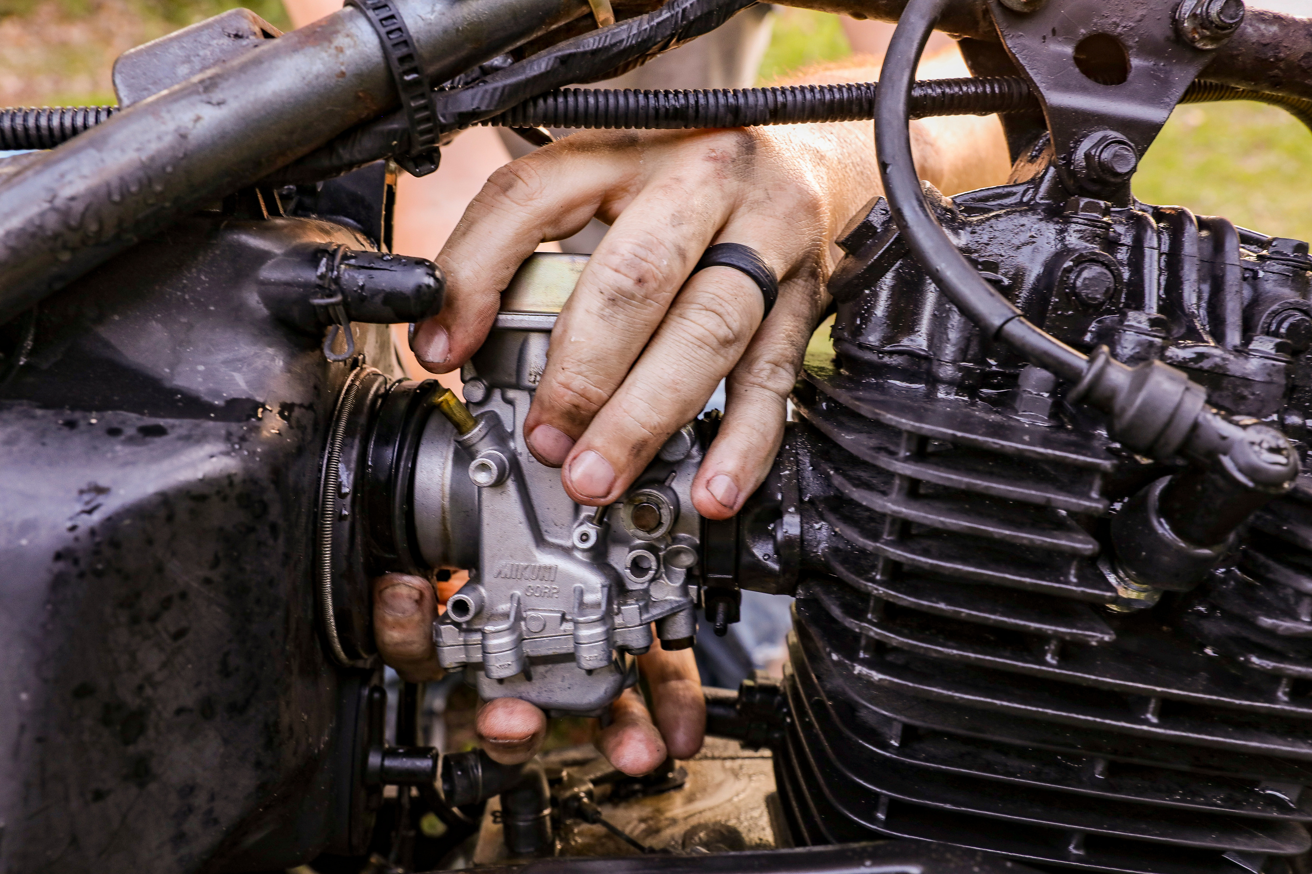 Close-Up Shot of a Person Fixing an Engine of a Motorcycle